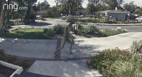 A fake alien crossing a Ring doorbell camera.