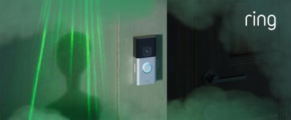 An alien standing next to a Ring camera.